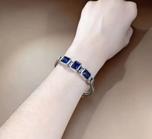 Detailed view of COBALT Bracelet clasp and handwoven iron band with cobalt-blue gemstone detailing