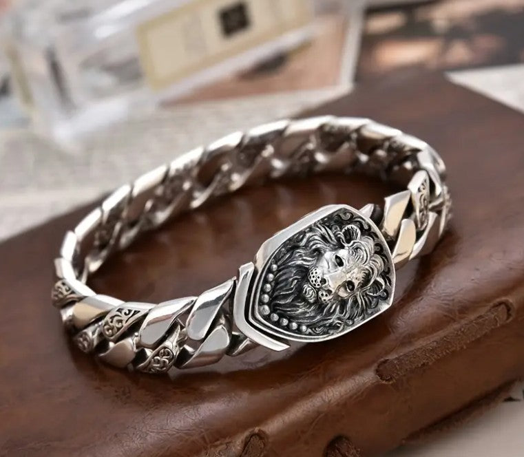 MEDICI Lion-Head Chain Bracelet with bold metal links and detailed lion clasp, displayed on neutral surface for premium styling