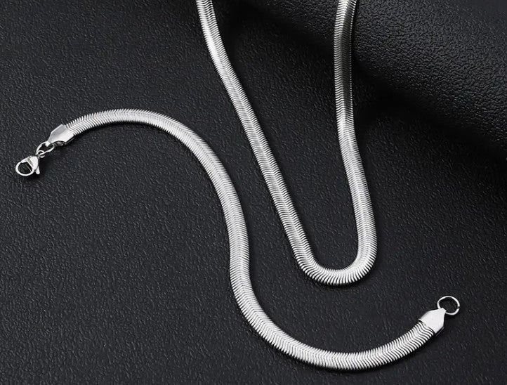 SARP Flat Snake Chain Bracelet with sleek stainless steel links displayed on black textured background, showcasing minimalist urban design