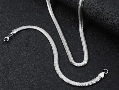 SARP Flat Snake Chain Bracelet with sleek stainless steel links displayed on black textured background, showcasing minimalist urban design