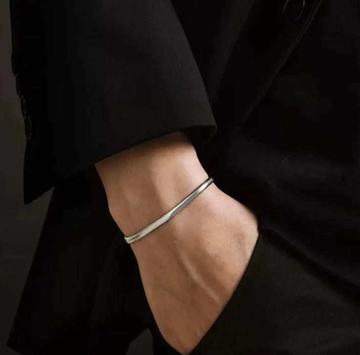 SARP Snake Chain Bracelet styled on wrist with black outfit, highlighting rebellious stainless steel silhouette and confident streetwear appeal