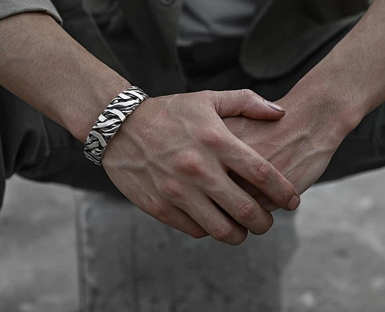 STRIKE Wide Cuff Bracelet displayed on black surface, highlighting textured silver finish and bold silhouette