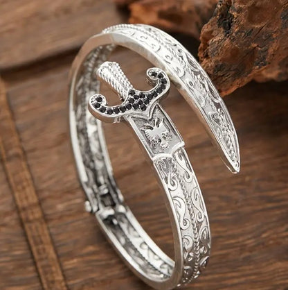 Close-up of GLADIUS Bracelet’s engraved sword motif and open-cuff structure on black surface