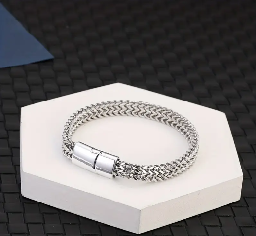 STRATUM Bracelet laid out on white platform with black background, highlighting craftsmanship