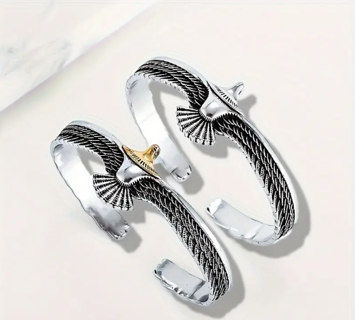 ODIN’S EAGLE Cable Cuff Bracelets with silver twisted band and eagle centerpiece in black and gold variants, displayed on wooden surface