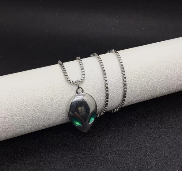 Pair of SPOCK Alien Pendant Necklaces featuring metallic alien head pendants with green eyes and silver chains, styled for bold streetwear looks