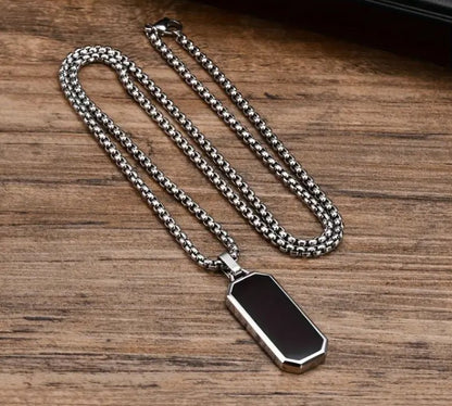 VEGAS Black Enamel Pendant Necklace laid flat on wooden surface, highlighting chain detail and pendant craftsmanship