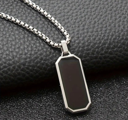 Men’s VEGAS Black Enamel Pendant Necklace displayed on textured black surface, showcasing sleek enamel finish and polished metallic border