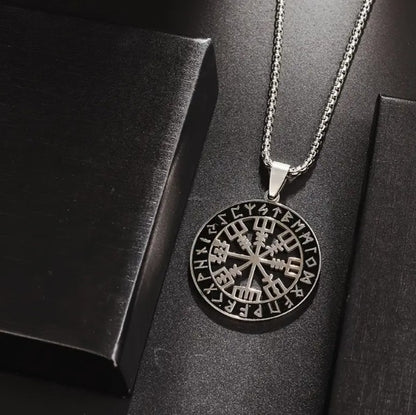 VEGVISIR Norse Compass Pendant Necklace with Viking rune medallion displayed on dark textured surface, showcasing polished stainless steel and intricate Nordic design