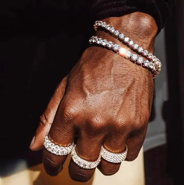 Hand adorned with DSTONE Crystal Tennis Bracelets and rings, featuring iced-out zircon stones and luxury hip hop aesthetic